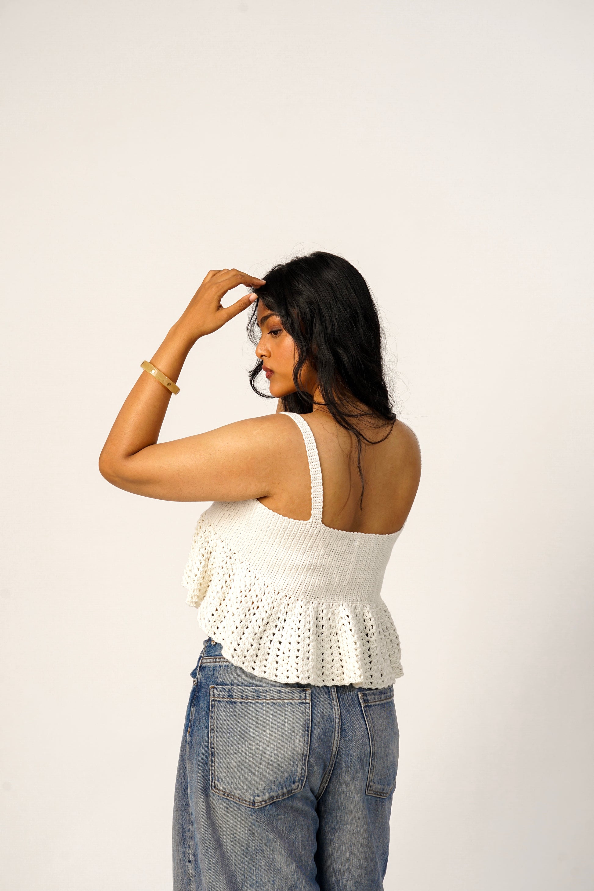Back view of ivory crochet flare top with soft flared silhouette