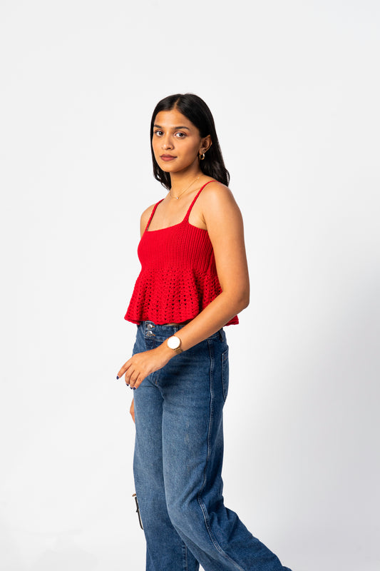 Woman wearing a red top and blue jeans on a white background