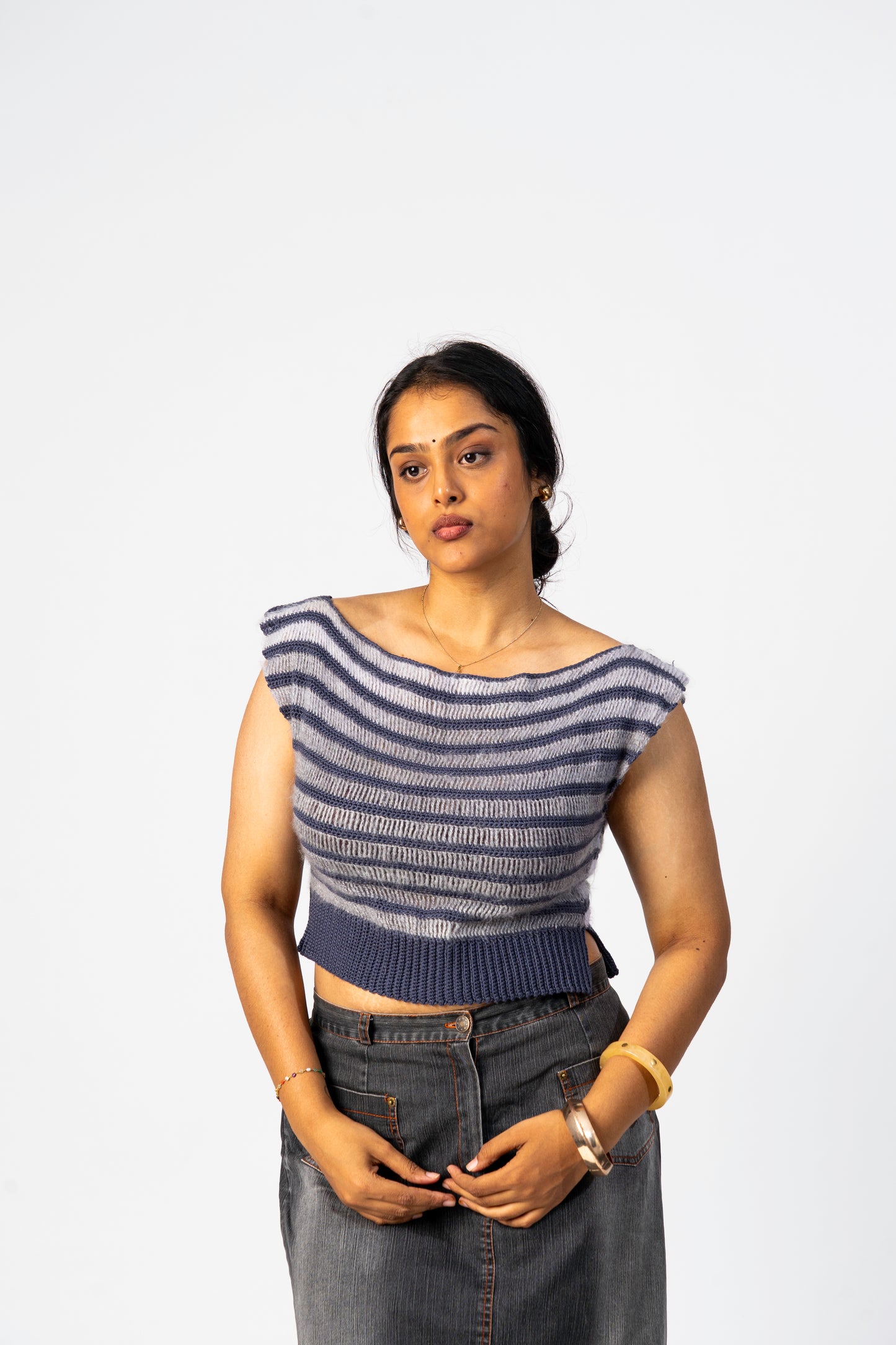 Woman wearing a striped top and jeans against a white background